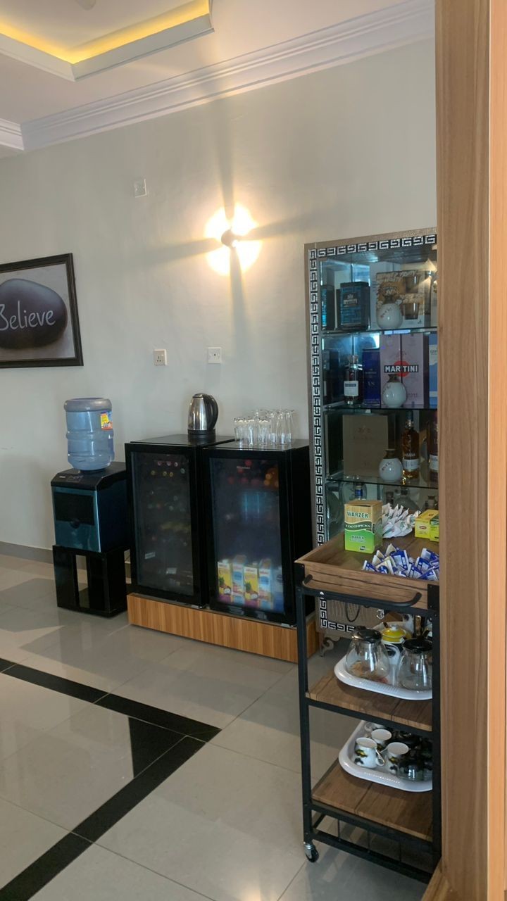 Office break area with water dispenser, mini fridges, and snack cart.